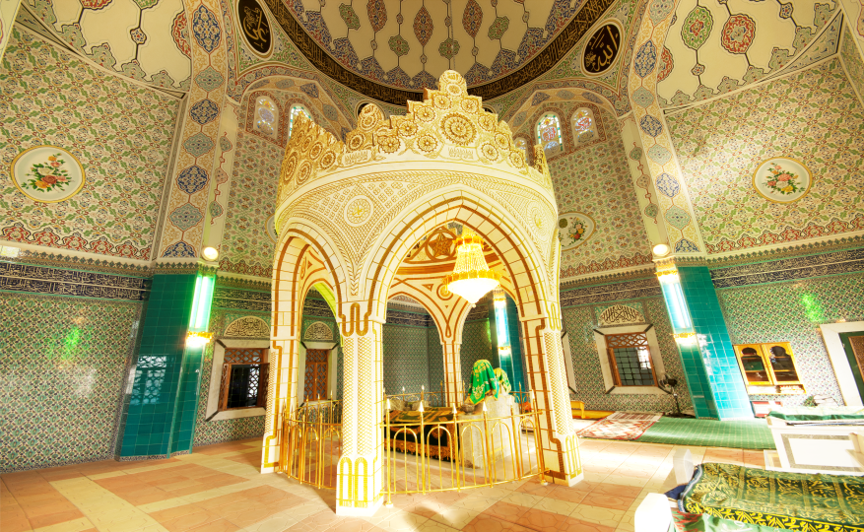Kunstvoll verzierter Innenraum einer Moschee mit goldenem Mihrab
